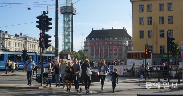 지난달 29일(현지 시간) 노르웨이 오슬로의 중앙역 앞 거리에서 보행자들이 차도를 건너고 있다. 승용차와 버스, 
노면전차(트램) 등이 수시로 오가는 도로이지만 ‘보행자 우선 문화’ 덕분에 보행자들은 차량 운전자의 양보로 안전하게 길을 건널 수
 있다. 오슬로=서형석 기자 skytree08@donga.com
