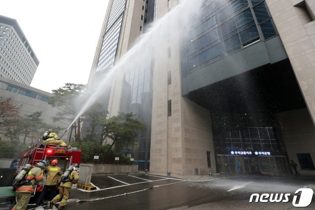 지난 3월 서울 중구 우리은행 본점에서 열린 ‘전국 화재대피 훈련’에서 소방대원들이 화재진압 훈련을 하고 있다. 2019.3.20/뉴스1 © News1