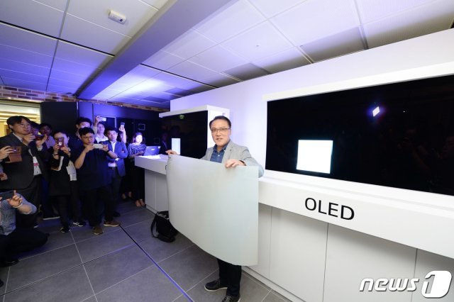 지난 17일 서울 여의도 LG트윈타워에서 열린 LG전자 디스플레이 기술설명회에서 LG전자 HE연구소장 남호준 전무가 패널의 차이를 설명하기 위해 국내시장에 판매중인 QLED TV에 적용된 퀀텀닷 시트를 들고 있다. (LG전자 제공)