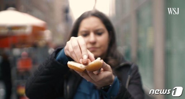 월스트리트저널(WSJ)의 테크 칼럼니스트 조안나 스턴이 지난 4월19일 게재한 동영상에서 갤럭시 폴드에 소시지를 끼워 넣는 퍼포먼스를 하고 있다. (출처 : 유튜브 갈무리) © 뉴스1