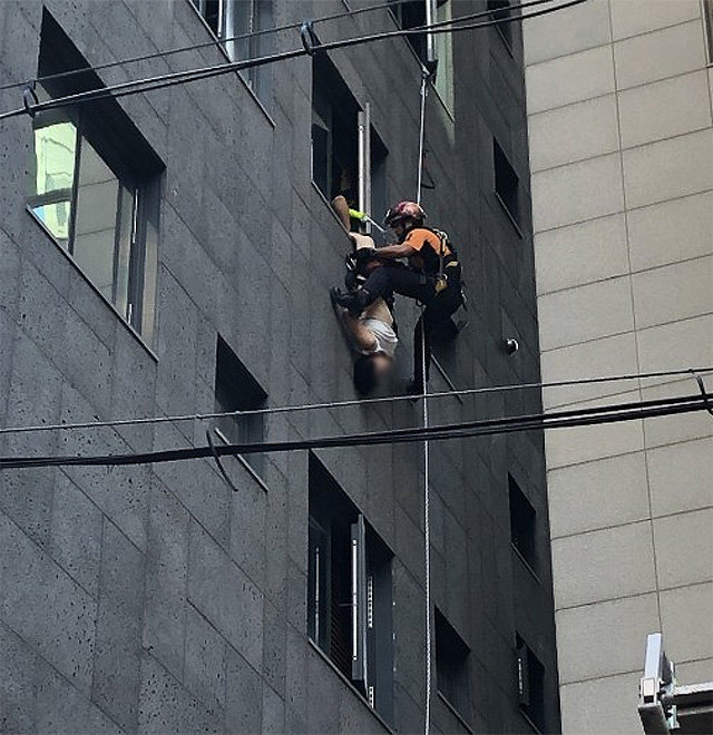30일 오전 서울 강남구 역삼동의 한 호텔 창틀 밖으로 몸을 드러낸 중국인 여성을 119구조대원이 구조하고 있다. 독자 제공
