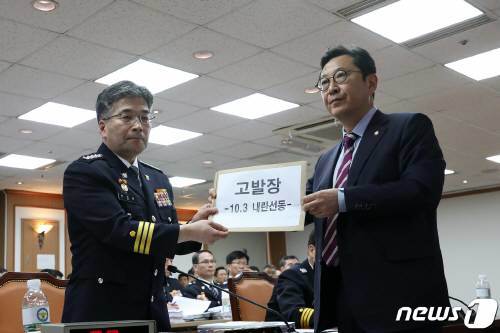 민갑룡 경찰청장이 4일 오전 서울 서대문구 경찰청에서 열린 국회 행정안전위원회의 경찰청 국정감사에서 김한정 더불어민주당 의원으로부터 지난 3일 광화문 보수단체 집회 관련 고발장을 받고 있다. 사진=뉴스1