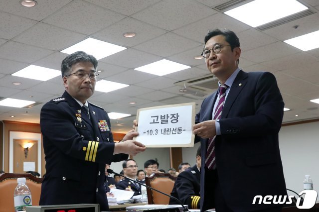 민갑룡 경찰청장이 지난 4일 오전 서울 서대문구 경찰청에서 열린 국회 행정안전위원회의 경찰청 국정감사에서 김한정 더불어민주당 의원으로부터 지난 3일 광화문 보수단체 집회 관련 고발장을 받고 있다. /뉴스1 © News1