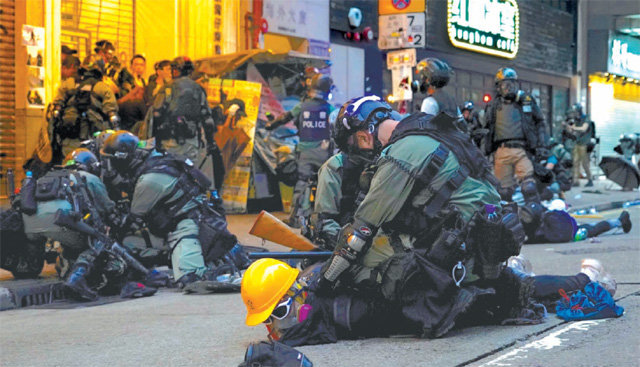 6일 홍콩 경찰이 마스크, 짙은 색 물안경, 안전모 등을 쓴 시위대를 땅에 눕힌 채 거칠게 진압하고 있다. 시위대는 이날 정부가 전날부터 시행한 ‘복면금지법’에 반대하기 위해 마스크를 쓴 채 ‘반(反)복면금지법’ 시위에 나섰다. 홍콩=AP 뉴시스