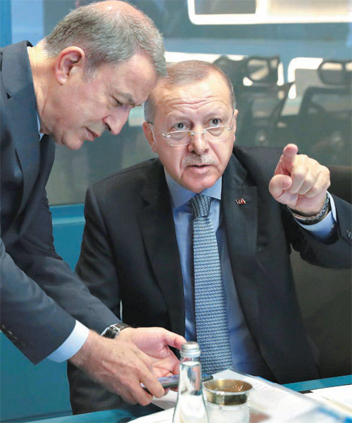 레제프 타이이프 에르도안 터키 대통령(오른쪽)이 9일 수도 앙카라 대통령궁 작전실에서 훌루시 아카르 국방장관과 시리아 북부에서의 군사 작전을 논의하고 있다. 앙카라=AP 뉴시스