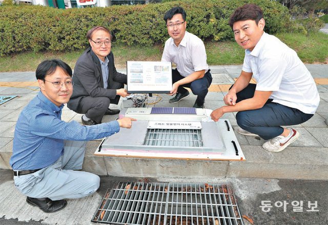 ‘금천구 발명팀’으로 불리는 서울 금천구 치수과 직원들이 직접 개발한 배수구 자동 개폐장치 ‘스마트 빗물받이’에 대해 설명하고 있다. 스마트 빗물받이는 평소엔 배수구를 덮어 오물이 쌓이는 것을 막고 비가 내릴 때만 열려 빗물을 처리한다. 왼쪽부터 이동섭 주무관, 허원회 치수과장, 김창신 하수팀장, 함대용 주무관. 김재명 기자 base@donga.com