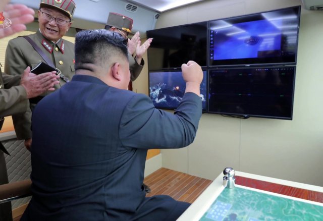김정은 북한 국무위원장이 8월 16일 시험사격을 지켜보면서 주먹을 불끈 쥐고 있다. 사진=동아일보DB