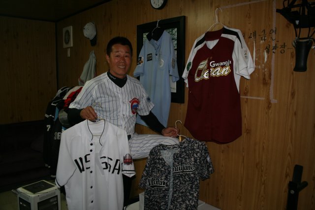 윤진숙 씨가 8일 경기도 용인에버야구장 사무실에서 자신이 속해 있는 팀의 유니폼을 들고 활짝 웃고 있다.