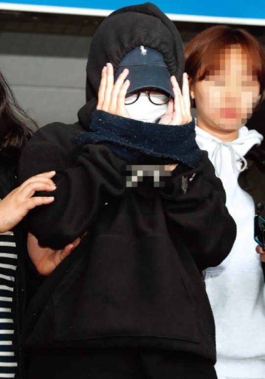 2018년 5월 한 남성의 신체를 불법촬영해 유포한 혐의로 체포된 여성 용의자가 조사 후 서울 마포구 마포경찰서에서 이송되고 있다. [뉴스1]