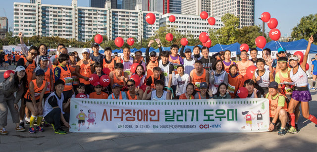 OCI 임직원들이 12일 서울 여의도 한강공원에서 열린 시각장애인 마라톤 대회 도우미 활동을 시작으로 사회공헌 활동을 시작했다. OCI 제공