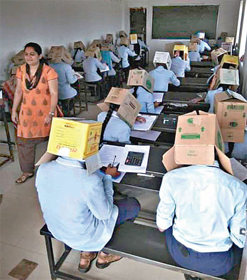 16일 인도 카르나타카주 하베리에 위치한 한 대학교에서 학생들이 머리에 종이 상자를 쓰고 시험을 치르고 있다. 사진이 유포된 후 “비인간적”이란 비판이 제기되자 학교 측은 “부정행위를 방지하기 위한 조치였다”며 “어떤 강요도 없었다”고 해명했다. ANI 트위터
