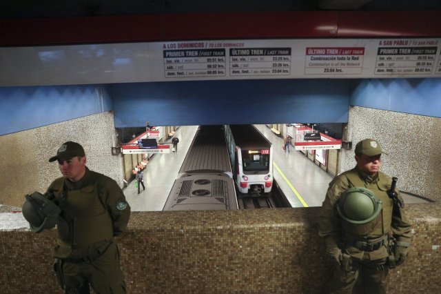 지난 21일 노선 4개 중 단 한 개가 운영중인 지하철 앞에서 을 시위 진압 경찰 경계를 서고 있다. [산티아고=AP/뉴시스]