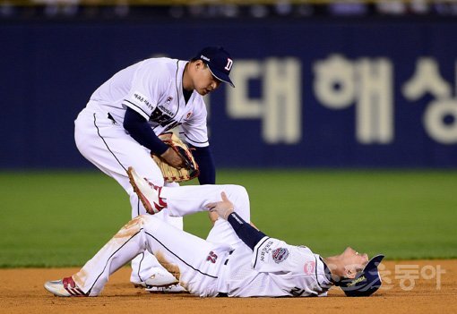 22일 서울 잠실야구장에서 ‘2019 신한은행 MY CAR KBO 포스트시즌’ 한국시리즈 1차전 키움 히어로즈와 두산 베어스의 경기가 열렸다. 두산 김재호(오른쪽)가 6회초 이닝을 마친 후 다리에 쥐가 올라와 고통스러워하고 있다. 잠실｜김진환 기자 kwangshin00@donga.com