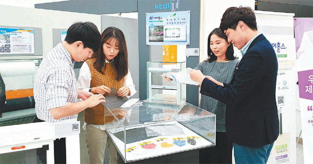 22일 대구 서구 한국섬유개발연구원 1층 전시관에서 방문객들이 서로 다른 업종의 융합제품인 미세먼지 창문 필터를 살펴보고 있다. 한국섬유개발연구원 제공