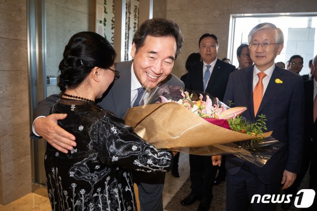 이 총리가 동아일보 도쿄 특파원 시절 동료 서순자씨로부터 꽃다발을 받고 포옹하고 있다. 오른쪽은 남관표 주일대사. 뉴스1