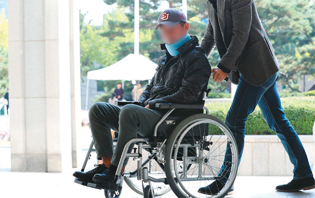 조국 전 법무부 장관의 동생 조모 씨가 지난달 21일 오후 서울 서초동 서울중앙지방검찰청에 목보호대를 하고 휠체어를 탄 채 출석하고 있다. 뉴스1