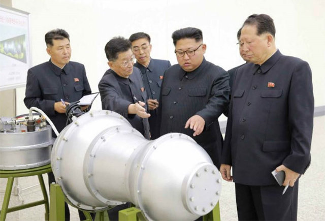 김정은 북한 노동당 위원장(오른쪽에서 두 번째·현 국무위원장)이 2017년 9월 핵무기 병기화 사업지도현장에서 대륙간탄도미사일 장착용으로 추정되는 수소탄에 대한 설명을 듣고 있다. 사진 출처 노동신문