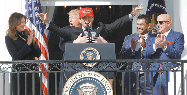 백악관서 월드시리즈 우승팀 맞이한 트럼프 도널드 트럼프 미국 대통령(왼쪽에서 두 번째)이 4일 워싱턴 백악관에서 2019 메이저리그 월드시리즈 우승 팀인 워싱턴 내셔널스의 포수 커트 스즈키(가운데)를 뒤에서 포옹하고 있다. 이날 미 해병대 군악단은 워싱턴 선수단이 입장할 때 사실상 비공식 주제가 역할을 하는 ‘아기 상어’를 연주했다. 아기 상어는 한국 유아 콘텐츠 기업 ‘핑크퐁’이 북미의 구전 동요를 각색한 노래로 ‘뚜루루뚜루’란 중독성 있는 후렴구로 큰 인기를 끌고 있다. 트럼프 대통령도 “강렬하고 귀여운 노래”라고 평했다. 워싱턴=AP 뉴시스
