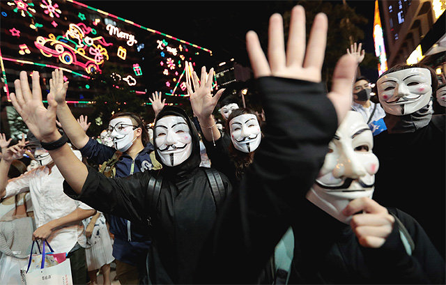 다섯 손가락 펼친 홍콩 시위대 시위대의 마스크 착용을 금지하는 복면금지법 시행 한 달을 맞은 5일 
홍콩에서 반중 시위대가 ‘저항의 상징’으로 통하는 ‘가이 포크스’ 가면을 쓴 채 시위를 벌이고 있다. 홍콩을 담당하는 한정 
부총리는 6일 캐리 람 행정장관에게 “폭동을 진압하고 질서를 회복하는 것은 홍콩 행정·입법·사법기관 공통의 책임”이라며 무력진압을
 압박했다. 홍콩=AP 뉴시스