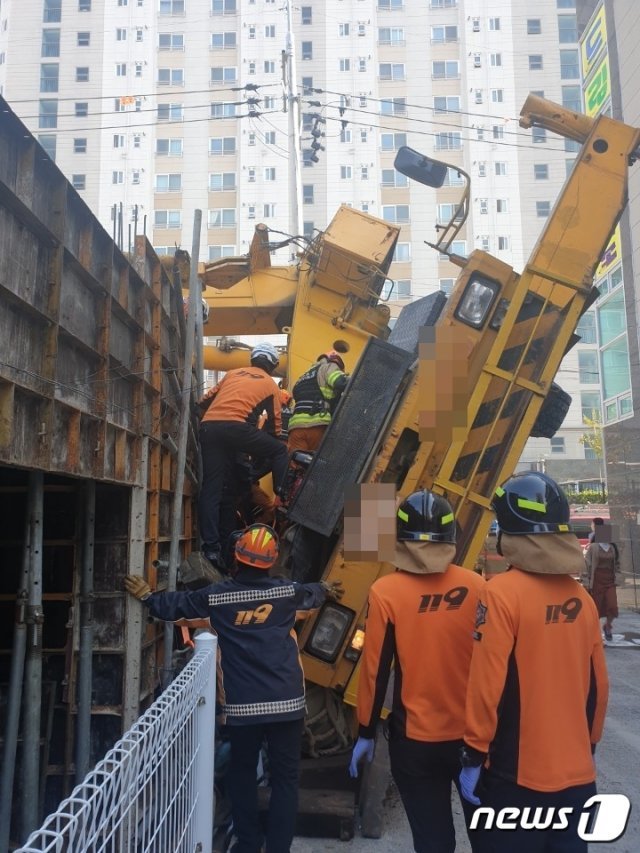 7일 낮 12시49분쯤 경남 양산시 명동 한 신축 원룸 공사장에서 37.6톤 크레인이 넘어져 소방대원들이 구조작업을 펼치고 있다.(경남소방 제공)2019.11.7.© 뉴스1