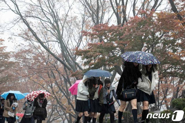 수도권과 강원북부 지역을 중심으로 비가 내리고 있는 15일 서울 중구 남산에서 관광객들이 우산을 쓰고 발걸음을 재촉하고 있다. 2019.11.15/뉴스1 © News1