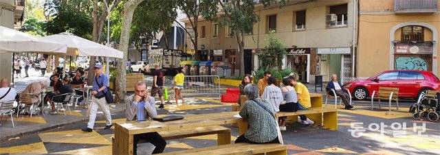 지난달 8일(현지 시간) 스페인 바르셀로나 시민들이 도심 슈퍼블록 구역 내에 설치된 테이블에 앉아있다. 테이블이 설치된 이 공간은 원래 자동차가 다니던 차로였다. 바르셀로나=윤다빈 기자 empty@donga.com