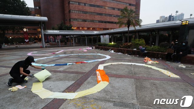19일 오후 홍콩 이공대학교에서 시위에 참여중인 학생이 수건을 이용해 SOS 문자를 만들고 있다. (홍콩=뉴스1)