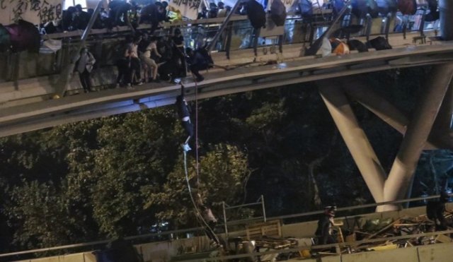 시위대가 홍콩 이공대 옆 육교에서 밧줄을 타고  탈출을 시도하고 있다.  다리 아래는 고속도로다. SCMP 갈무리