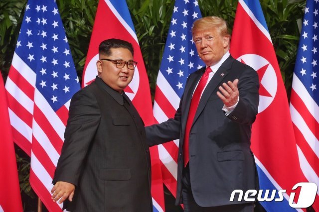도널드 트럼프 미국 대통령과 김정은 북한 국무위원장이 12일 오전 북미 정상회담이 열린 싱가포르 센토사섬 카펠라호텔에서 인사를 나누고 있다. (싱가포르통신정보부 제공) 2018.6.12/뉴스1