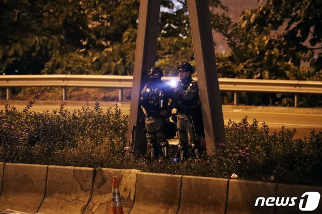홍콩 경찰들이 19일 오후  이공대 교정을 빠져 나가는 시위대 학생을 체포하기 위해 경계 근무를 서고 있다. 2019.11.19/뉴스1 © News1