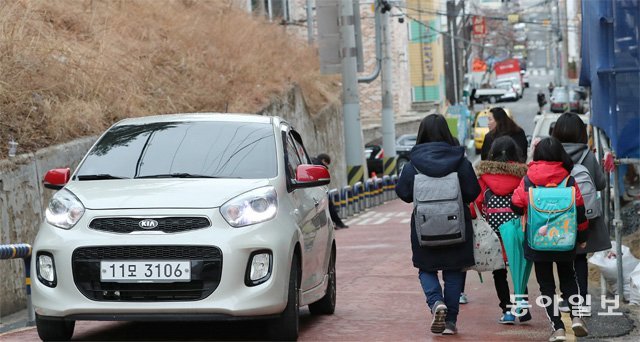 한 초등학교 앞 어린이보호구역(스쿨존) 도로에서 어린이들이 달리는 차를 피해 걷고 있다. 동아일보DB