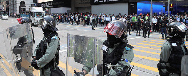넥타이 부대도 통제 20일 홍콩 금융가에서 중무장한 경찰이 시위대의 도로 진입을 차단하고 있다. 경찰은
 그동안 직장인들이 점심시간에 모여 구호 등을 외치며 평화 시위를 벌이는 것을 지켜봤으나 이날은 병력을 투입해 시위대 해산에 
나섰다. 홍콩=AP 뉴시스