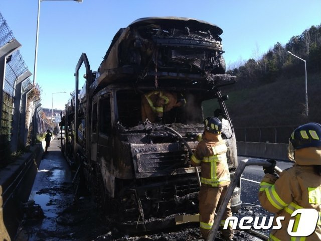 22일 오전 10시16분께 익산~장수 고속도로 장수 톨게이트 입구에서 신차량을 운반하는 트레일러에서 화재가 발생해 소방대원들이 진화하고 있다.(전북소방본부 제공) © News1