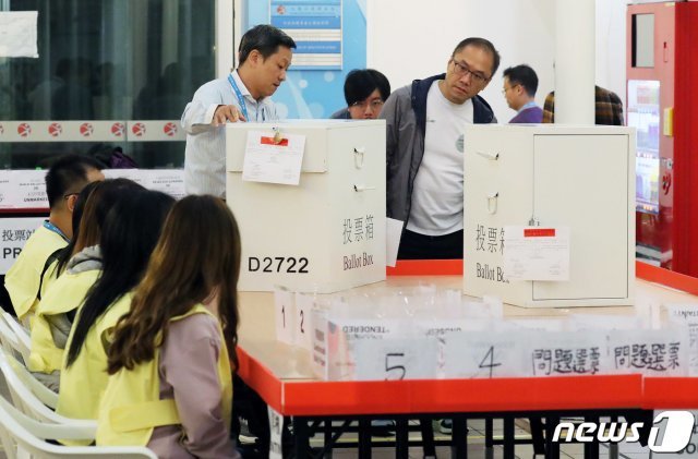 24일 홍콩 주룽 공원 수영장에서 관계자들이 투표함을 옮기고 있다. 2019.11.25/뉴스1 © News1