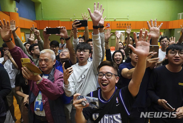 25일(현지 시간) 홍콩 범민주진영 앵거스 웡 지지자들이 전날 치러진 구의원 선거 개표 결과 승리가 확정되면서 환호하고 있다. 사진=뉴시스