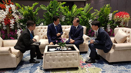 태국 방콕에서 열린 ‘아세안+3 정상회의’에 참석했던 문재인 대통령이 아베 신조 일본 총리와 11분 가량 예정에 없던 환담을 하는 모습. 문 대통령을 수행했던 정의용 안보실장이 휴대전화로 찍은 사진이다. 청와대 제공. 2019년 11월