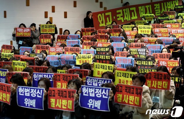 전국 외고ㆍ국제고 학부모 연합회 학부모들이 27일 오후 서울 중구 이화외고에서 전국외국어고등학교장협의회의 외고 폐지 정부 시행령 발표 관련 기자회견에서 플래카드를 들고 구호를 외치고 있는 모습.7/뉴스1 © News1