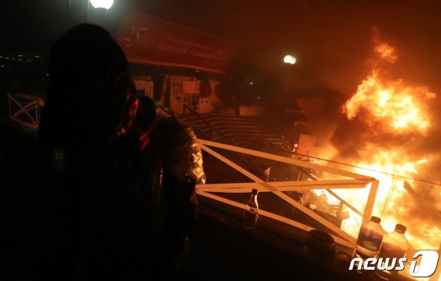 18일 오전 홍콩이공대에서 경찰이 진압하는 과정에서 화재가 발생해 학생들이 상황을 지켜보고 있다. 2019.11.18/뉴스1 © News1