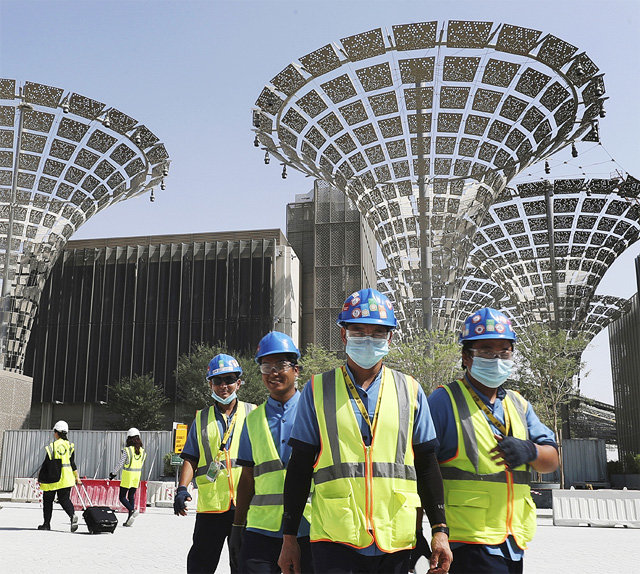지난달 8일 아랍에미리트(UAE) 두바이의 ‘엑스포 2020’ 행사 준비 현장에서 건설기술자들이 마스크와 안전모를 쓰고 걸어 
나오고 있다. 내년 10월 막 오르는 ‘엑스포 2020’에서 두바이는 외국인 투자와 관광객을 대거 유치해 재도약의 기회를 노린다.
 두바이=AP 뉴시스