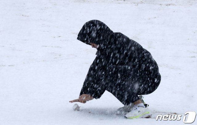 경기 일부 지역에 눈이 내린 3일 오전 군포시 산본고등학교에서 한 학생이 운동장에 쌓인 눈을 굴리고 있다. 2019.12.3/뉴스1 © News1