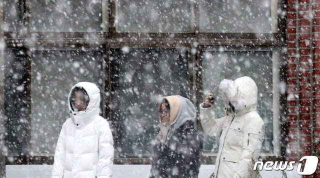 경기도 일부 지역에 눈이 내린 3일 오전 경기도 군포시 산본고등학교에서 학생들이 내리는 눈을 맞으며 추억을 남기고 있다. © News1