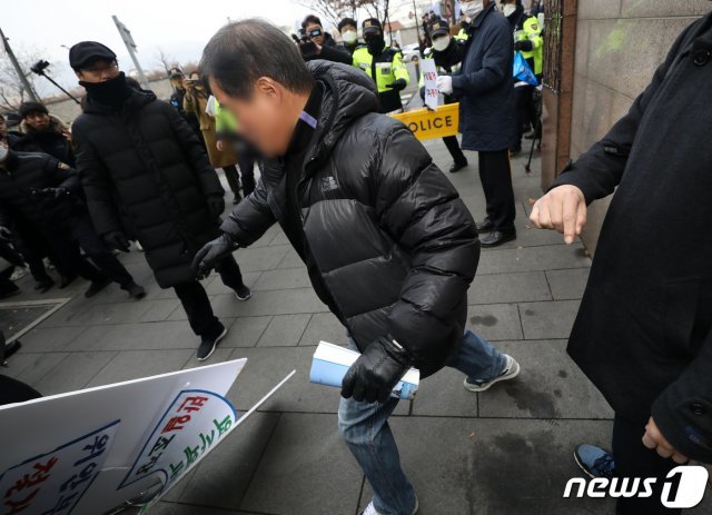 (서울=뉴스1)  일본군 성노예제 문제 해결을 위한 ‘’제1417차 정기 수요 시위‘’가 열린 11일 서울 종로구 옛 일본대사관 앞에서 수요시위 중단과 소녀상 철거를 주장하며 1인 시위를 벌이던 ‘’반일종족주의‘’ 저자 이우연 낙성대경제연구소 연구위원의 피켓을 한 시민이 달려들어 피켓을 발로 차 부수고 있다. 2019.12.11/뉴스1