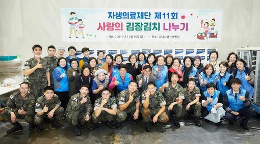 신민식 자생의료재단 사회공헌위원장(둘째줄 가운데)과 봉사자들이 소외 이웃들에게 전달할 김장김치 준비를 마치고 사진 촬영을 하고 있다. 사진제공｜자생의료재단