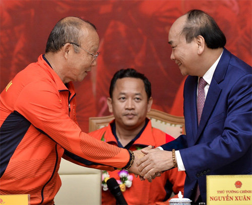 베트남 남자축구를 60년 만에 동남아시아(SEA)경기 정상에 올려놓은 박항서 감독(왼쪽)이 11일 베트남 하노이의 총리 공관에서 응우옌쑤언푹 베트남 총리(오른쪽)와 악수하고 있다. 베트남 징 캡처