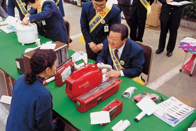 1992년 4월 구자경 회장(오른쪽 앉아있는 인물)이 금성사(현 LG전자) 일일서비스 요원으로 낫 고객의 불편사항을 직접 듣고 있다.