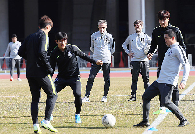 파울루 벤투 한국 축구대표팀 감독(왼쪽에서 세 번째)이 동아시안컵 최종전인 일본과의 경기를 이틀 앞둔 16일 부산아시아드 보조경기장에서 선수들의 패스 훈련을 지켜보고 있다. 한국은 일본을 꺾으면 대회 사상 최초로 3연속 우승이자 개최 국가 우승이라는 새 기록을 쓰게 된다. 부산=뉴시스