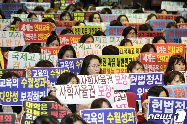 18일 오후 서울 중구 이화여자외국어고등학교에서 열린 자사·외·국제고 일괄 전환 방침 공동성명서 발표 기자회견에서 학부모들이 손피켓을 들고 구호를 외치고 있다. 이날 전국자사고외고국제고교장연합회는 성명서를 통해 “정부 정책에 따라 운영해 온 자사고, 외고, 국제고의 일괄 폐지가 적법한 것인지 헌법 소원을 제기해 투쟁할 것“이라고 밝혔다. 2019.12.18/뉴스1 © News1