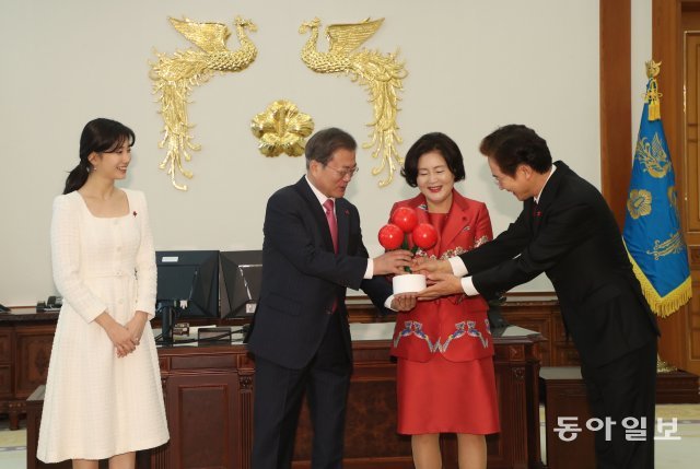 문재인 대통령이 20일 청와대 집무실에서 방송인 정보석 씨로부터 사회복지공동모금회를 상징하는 ‘사랑의열매’ 모형을 받고 있다. 왼쪽은 정 씨와 함께 사랑의열매 홍보대사로 활동하는 방송인 수지 씨.