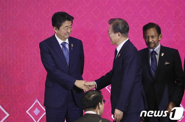 문재인 대통령과 아베 일본 총리가 4일 방콕 임팩트 포럼에서 열린 역내포괄적경제동반자협정(RCEP)에서 기념촬영 전 악수하고 있다. 뉴스1