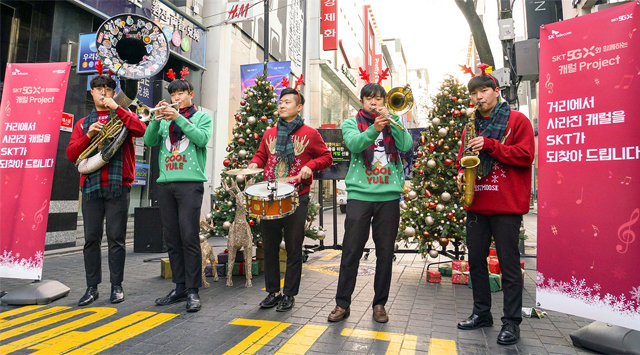 서울 중구 명동 한가운데에서 크리스마스 브라스밴드가 캐럴 공연을 하며 SK텔레콤의 ‘캐럴 이즈 백’ 프로젝트를 알리고 있다.